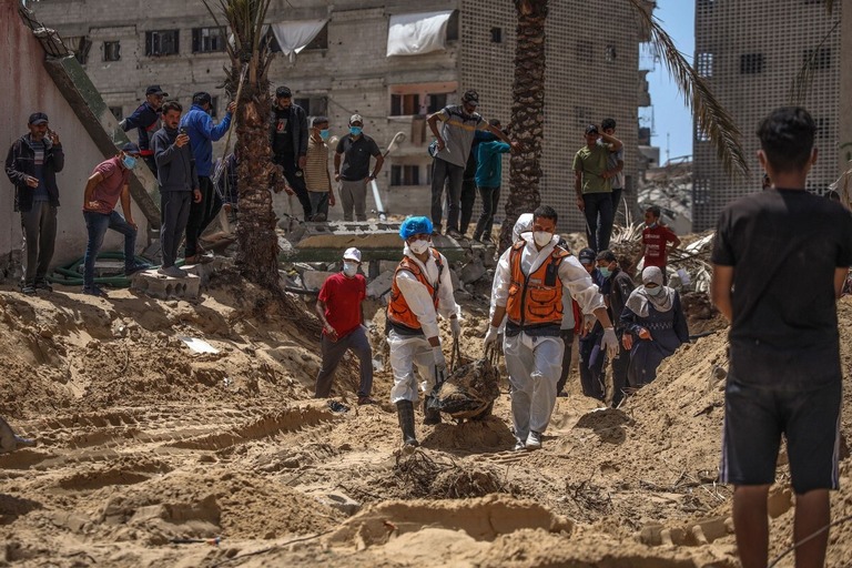 発見された遺体を移送する医療従事者ら＝２３日、パレスチナ自治区ガザ地区南部ハンユニスのナセル病院/AFP/Getty Images