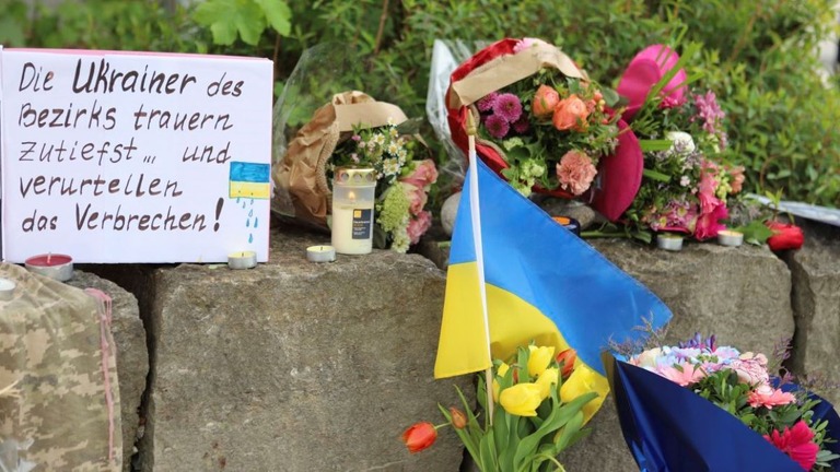 事件現場付近に手向けられた花やウクライナの国旗＝２８日、ドイツ・ムルナウ/Constanze Wilz/dpa/AP