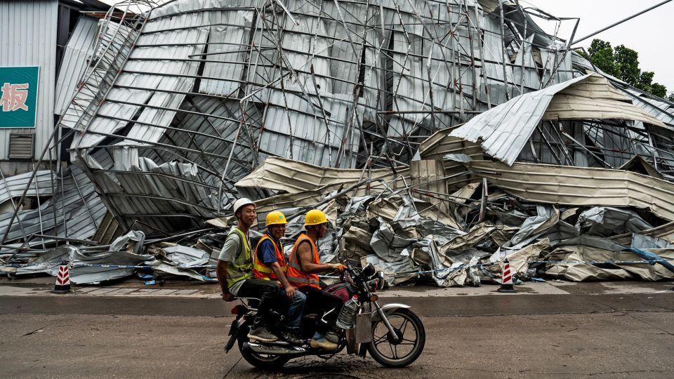 破壊された建物の横を移動する人たち/STR/AFP/Getty Images