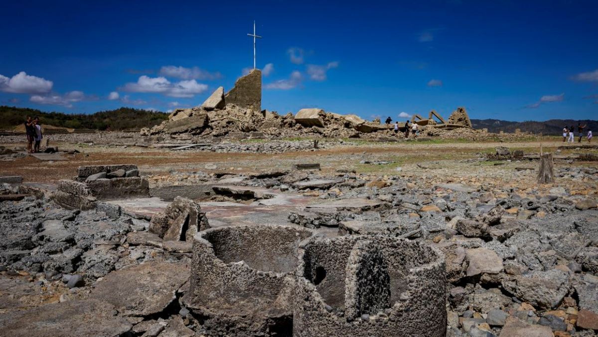 干上がったダムの底から出現した遺構を訪問する人々＝４月２８日、フィリピン・ヌエバエシハ州/Ezra Acayan/Getty Images