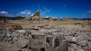 干上がったダムの底から出現した遺構を訪問する人々＝４月２８日、フィリピン・ヌエバエシハ州