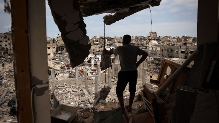 壊れた住宅から破壊された近隣を眺めるパレスチナ人の男性＝２日、パレスチナ自治区ガザ地区ハンユニス/AFP/Getty Images