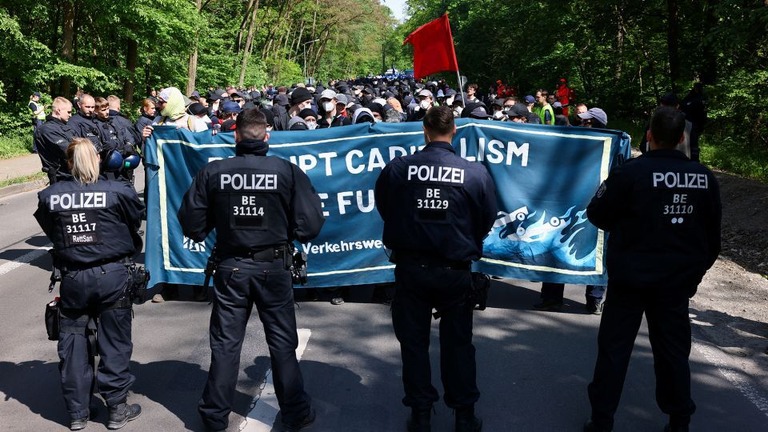 テスラ工場の生産拡大に反対してデモ行進する人々と警官隊が対峙/Christian Mang/Reuters