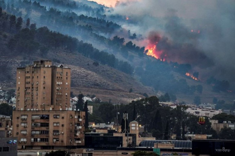 イスラエル北部の都市キリヤット・シュモナ近くの山から立ち上る炎と煙/Ayal Margolin/Reuters via CNN Newsource