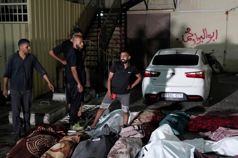 ６日未明、イスラエルによる学校への爆撃で犠牲になった人々を悼むパレスチナ人たち/Abdel Kareem Hana/AP