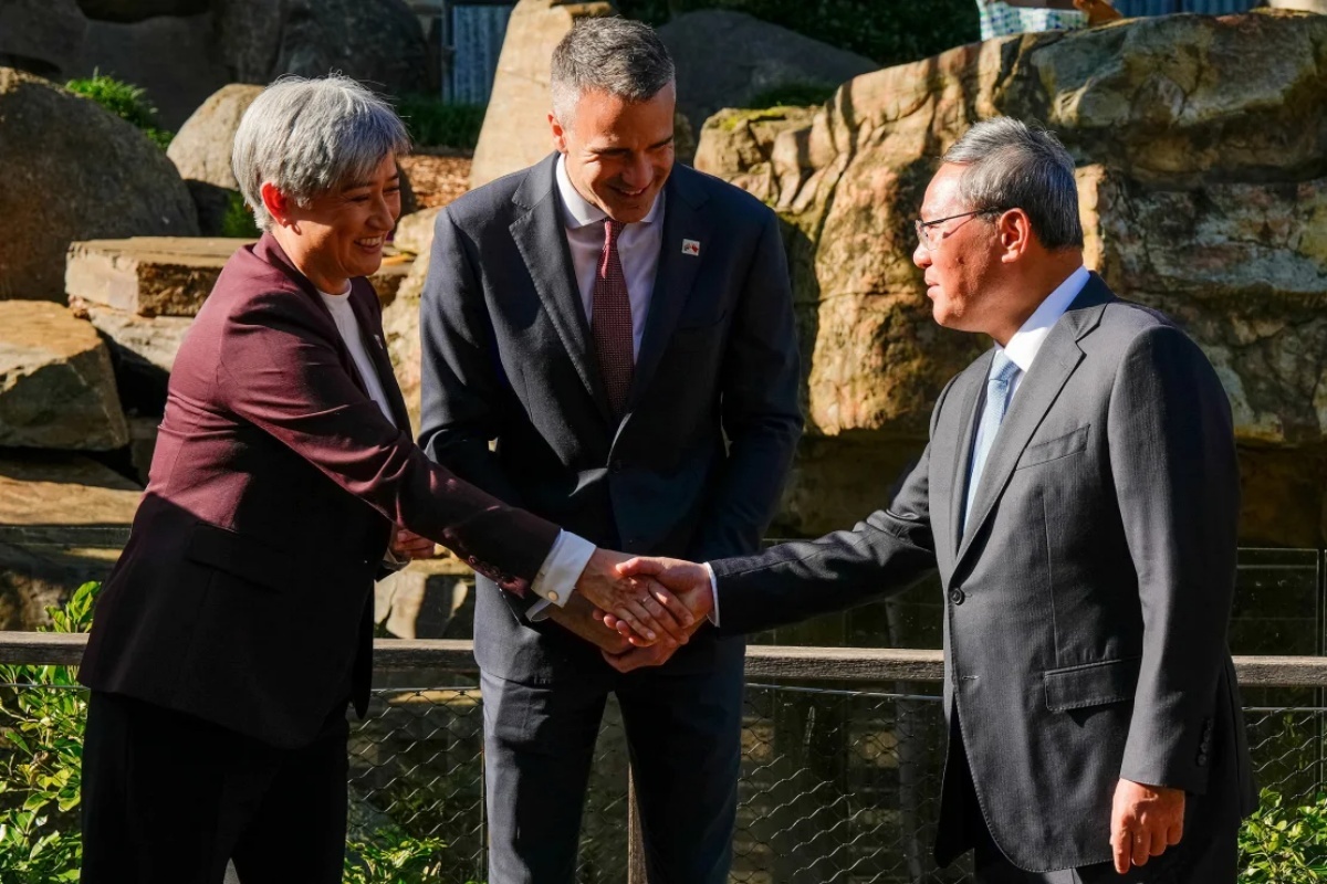 ペニー・ウォン豪外相(左)と握手する李強首相、中央はマリナウスカス南豪州首相=16日、アデレード動物園/Asanka Ratnayake/Pool/Reuters