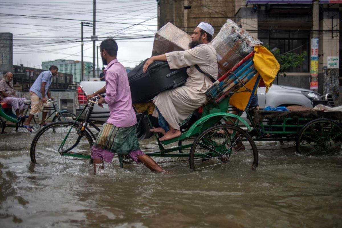 冠水した道路で荷物を運ぶ人たち=20日/Syed Mahamudur Rahman/NurPhoto/Getty Images