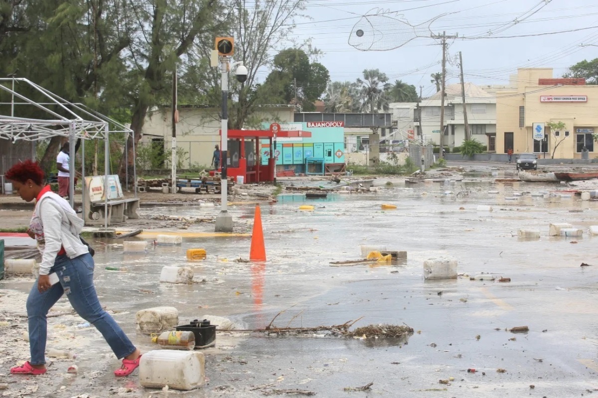 がれきなどが散乱した道路を移動する住民=バルバドス/Nigel R Browne/Reuters