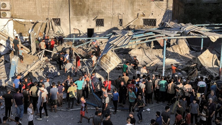 イスラエル軍の攻撃によって破壊された学校のがれきを探すパレスチナの人々/Eyad Baba/AFP/Getty Images