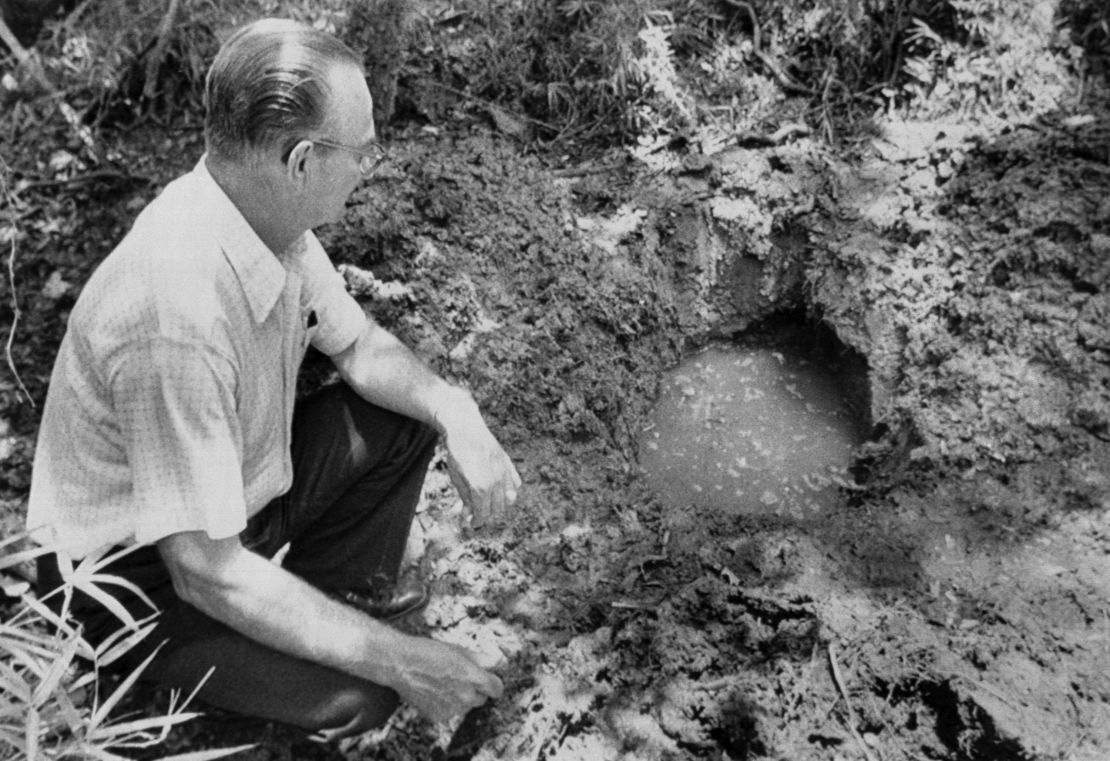 11歳の少年が埋められた場所の近くに座る保安官=ルイジアナ州/Bettmann Archive/Getty Images