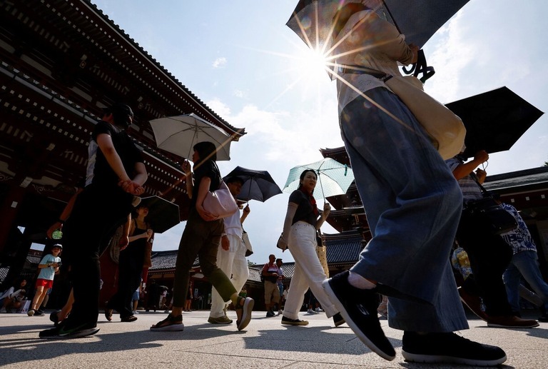 猛暑の中、日傘をさす人々＝２２日、東京
/Issei Kato/Reuters