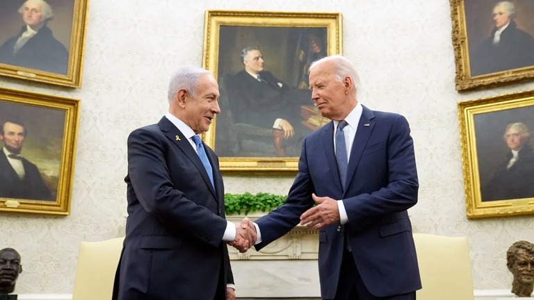 イスラエルのネタニヤフ首相（左）と握手を交わすバイデン米大統領（右）＝２５日、米ワシントンＤＣのホワイトハウス大統領執務室/Susan Walsh/AP