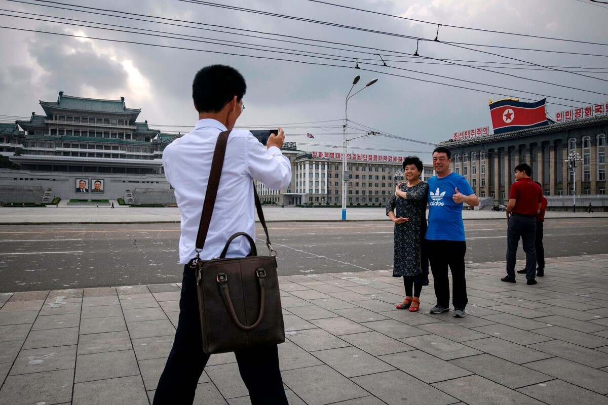 金日成広場で記念撮影をする中国からの観光客=2019年/Ed Jones/AFP/Getty Images