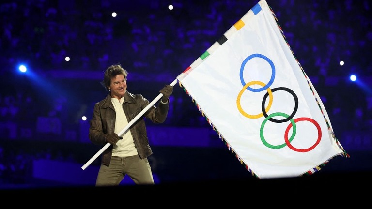 パリ五輪の閉会式でオリンピック旗を掲げるトム・クルーズ＝８月１１日、パリ郊外の競技場・スタッド・ド・フランス/Fabrizio Bensch/Pool/Getty Images