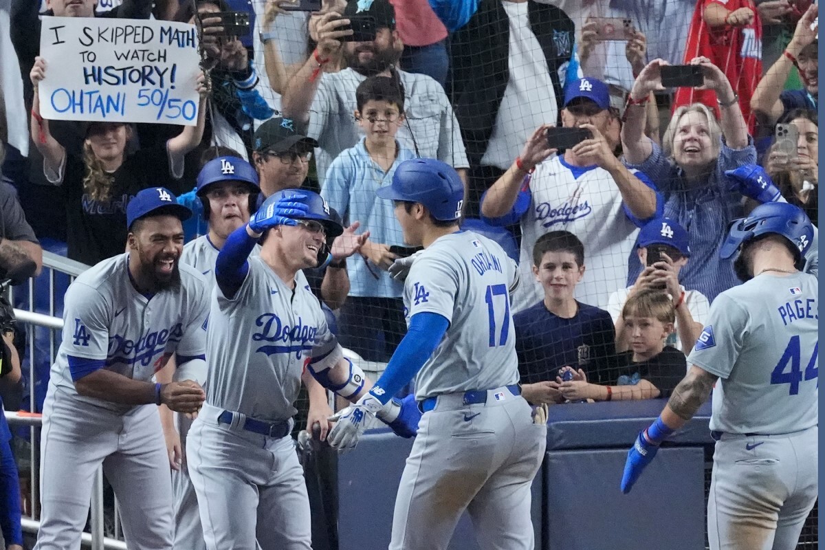 今シーズン50本目となるホームランを放ちチームメイトから祝福を受ける大谷選手=19日、米フロリダ州マイアミ/Wilfredo Lee/AP