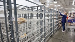ほとんど空っぽになった棚を調べる買い物客＝６日