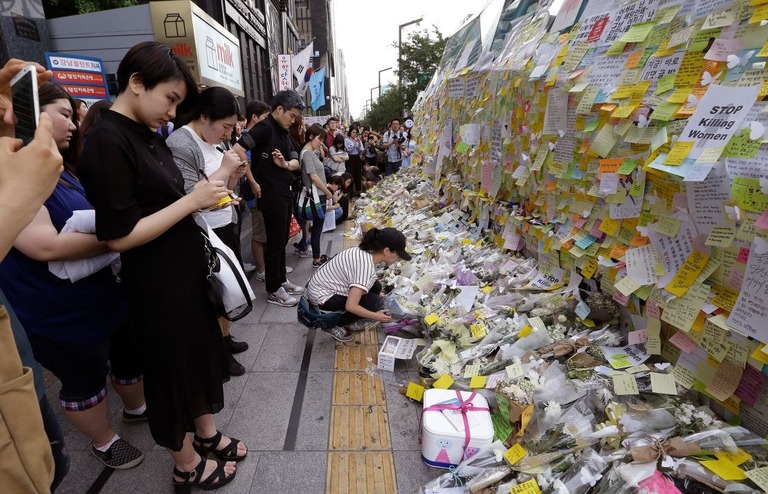 刺殺された女性を悼んで献花する人々＝２０１６年５月、韓国・ソウル/Ahn Young-joon/AP