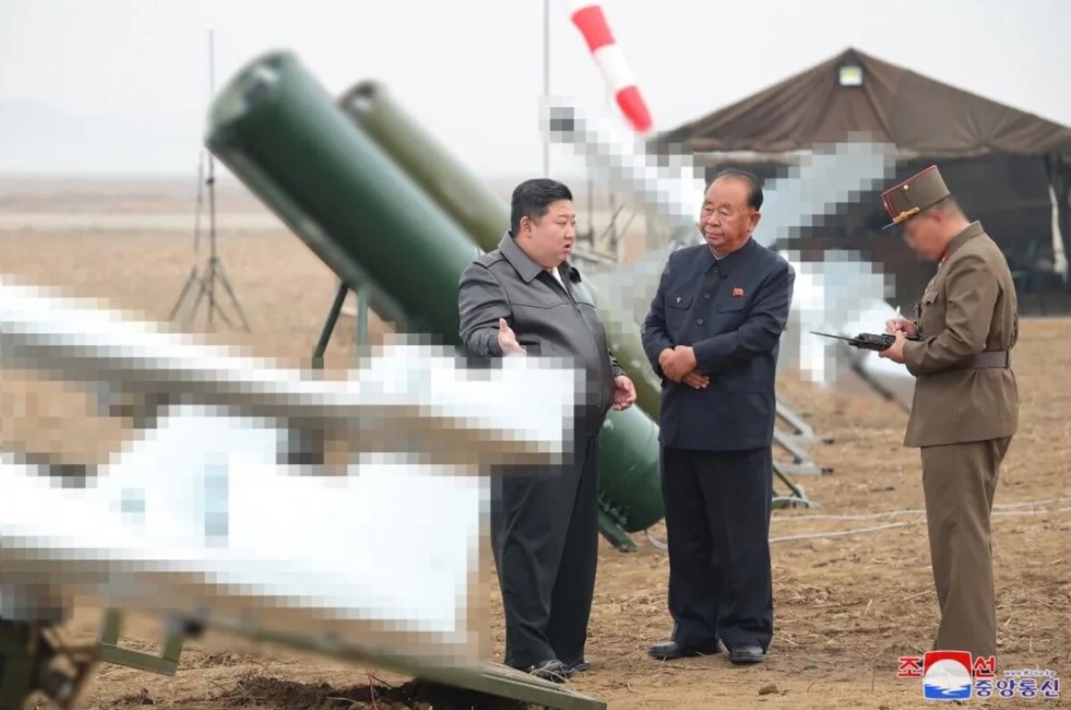 北朝鮮国営メディアによると、金総書記が自爆ドローンの試験飛行の視察中に当局者と話す様子/KCNA