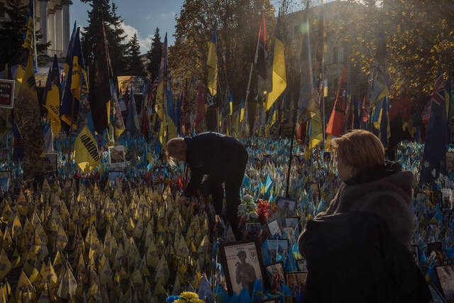 ウクライナと外国の戦闘員を追悼する仮設記念碑を訪れた人々。この日、ロシアがウクライナに侵攻してから１０００日が経過した＝１１月１９日、ウクライナ・キーウ/Roman Pilipey/AFP/Getty Images