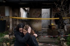 破壊された自宅の前で報道陣の取材に応じた後、女性が友人に抱き締められる様子。この女性は２３年１０月に人質となり、ハマスによって１１月に解放された