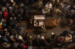 修道院で兵士のひつぎを取り囲み哀悼をささげる人々＝１月１１日、ウクライナ・キーウ