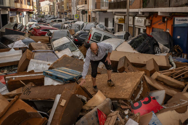 スペイン・バレンシアでがれきに覆われた通りを歩く男性。同国南部・東部では鉄砲水が発生、数時間で最大300ミリの大雨に見舞われた地域もあった。死者の大半は28年ぶりの豪雨となったバレンシア地方で発生した=10月30日/David Ramos/Getty Images