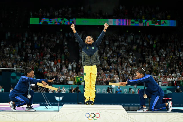 米体操選手シモーネ・バイルズ(左)とジョーダン・チャイルズが種目別ゆかで金メダルを獲得したブラジルのレベカ・アンドラデをたたえた。五輪の体操競技で初めて黒人選手が表彰台を独占した瞬間だった。しかし8月11日、国際オリンピック委員会は銅メダルをルーマニアのアナ・バルボスに授与しなおすと発表。これはスポーツ仲裁裁判所がチャイルズの得点に対する米国の申し立てが遅すぎたとの判決を下したためだった=8月5日/Gabriel Bouys/AFP/Getty Images