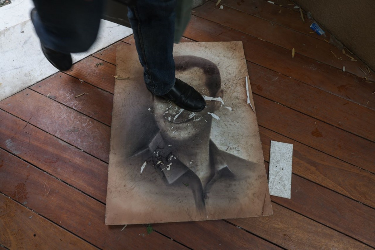 マリキ地区の大統領公邸に踏み込む際、アサド大統領の肖像画が踏みつけられていた=8日