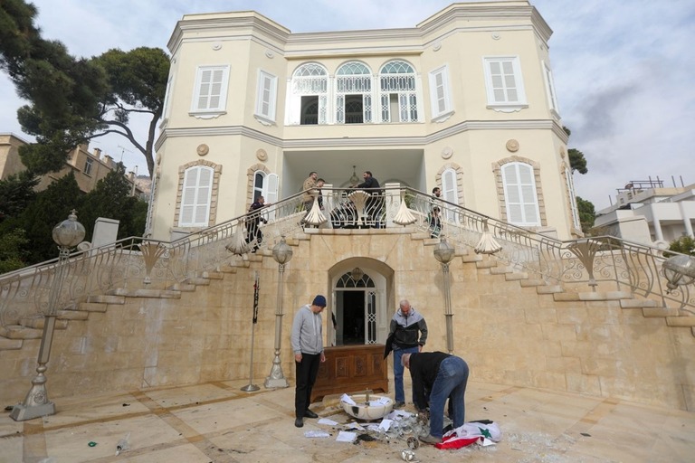 アサド大統領公邸の入り口からシリア国旗を撤去する人々＝８日、ダマスカス/Bakr Al Kassem/AFP/via Getty Images