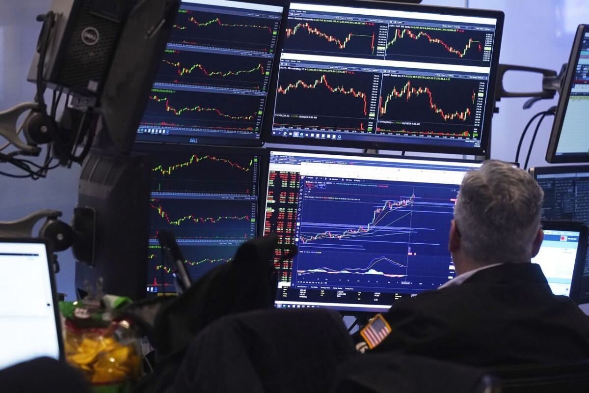 取引画面を確認するトレーダー=18日、米ニューヨーク証券取引所/Richard Drew/AP
