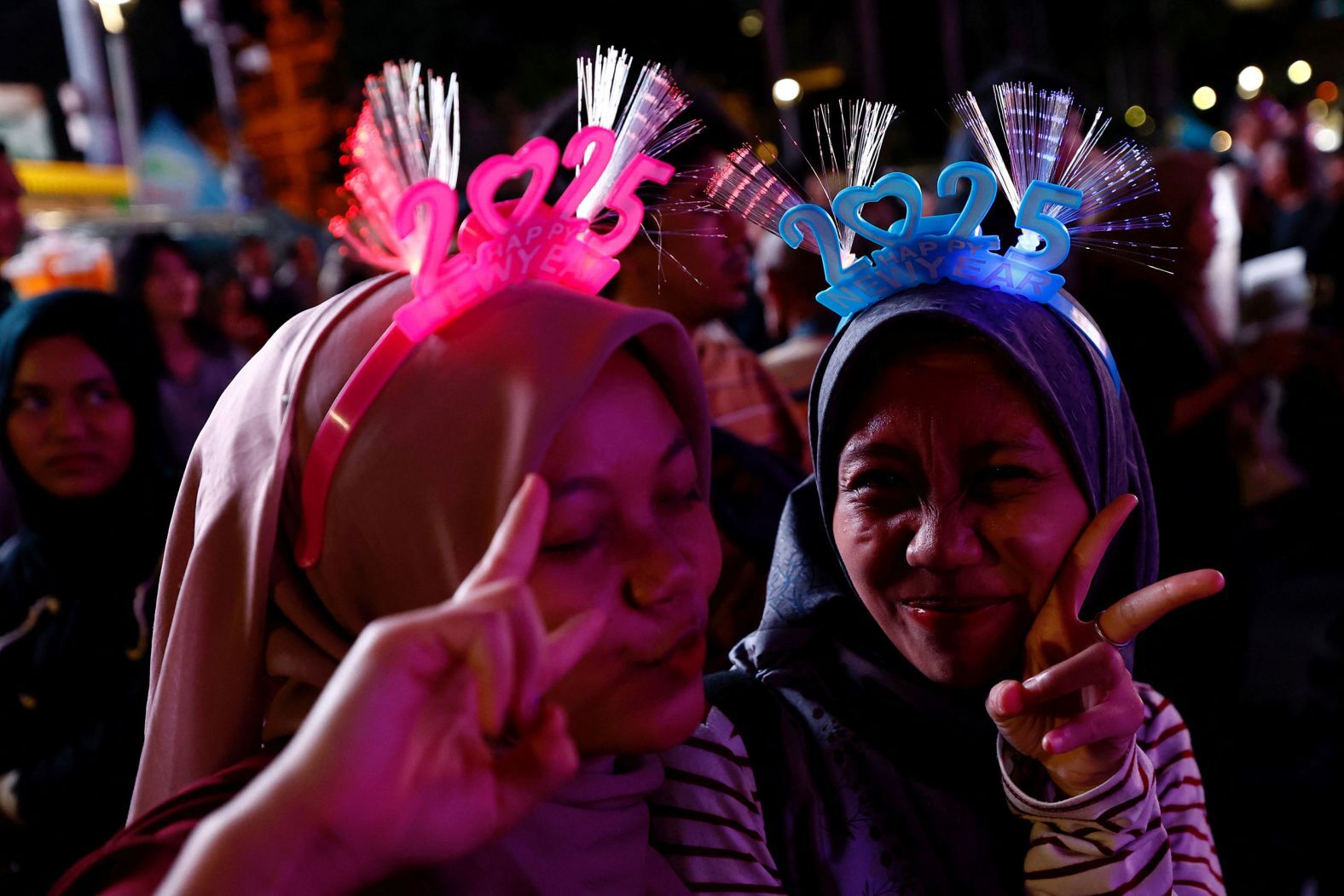 ２０２５年の文字をあしらったヘッドバンドを身に着けた女性たち＝ジャカルタ/Willy Kurniawan/Reuters