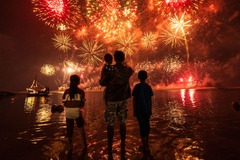 ジャカルタのビーチで花火を眺める地元住民＝インドネシア