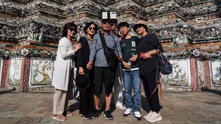 バンコクにあるワット・アルン寺院の前で記念撮影する中国人旅行者/Anusak Laowilas/NurPhoto/Getty Images