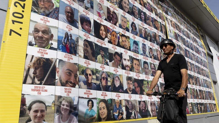 人質の写真を示した建物のそばを通る男性＝３月２６日、テルアビブ/Amir Levy/Getty Images