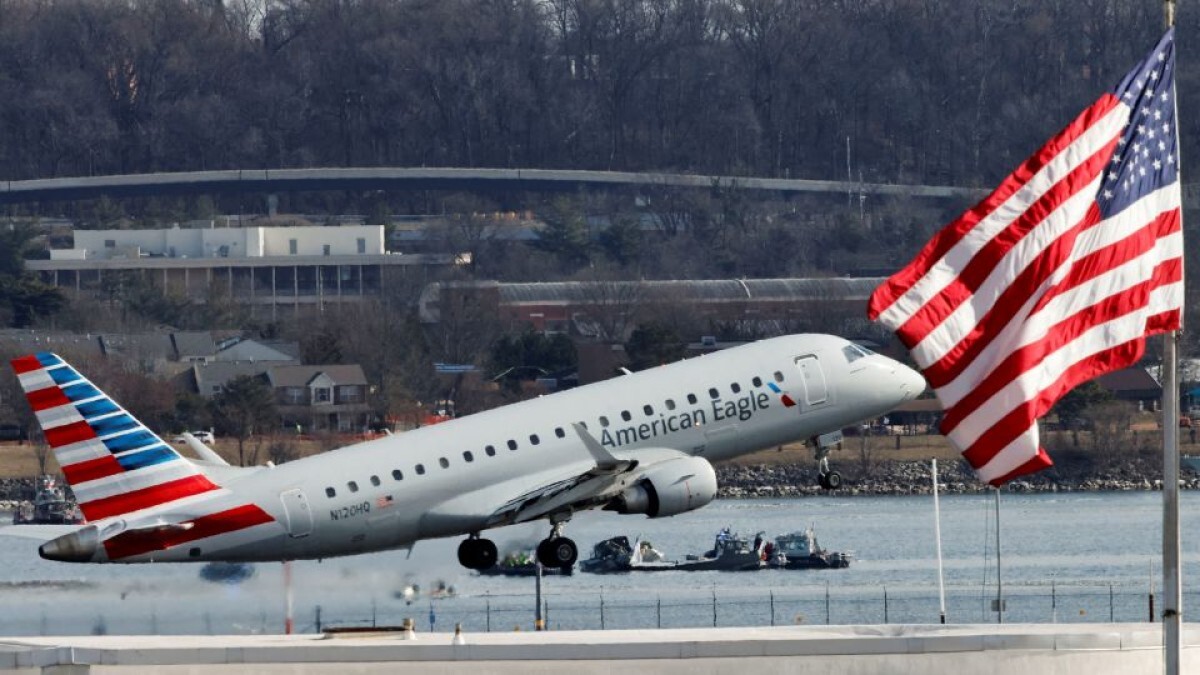 離陸するアメリカン・イーグルの航空機=30日、米レーガン・ナショナル空港/Emergency response units