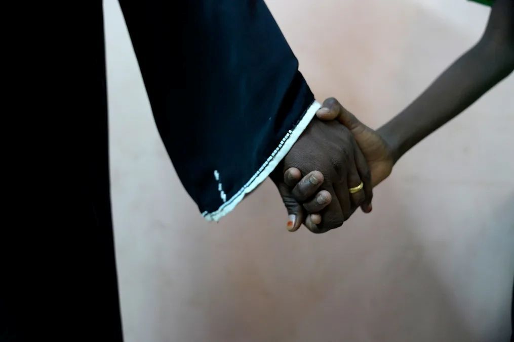 レイプ被害についての心の治療を受けた後、母親の手を握る11歳の男児/Tess Ingram/UNICEF