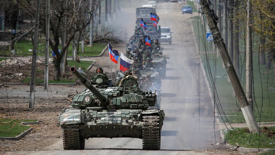 占領したウクライナ南東部の都市マリウポリの街路を走行するロシア軍の車列=2022年4月21日撮影/Chingis Kondarov/Reuters