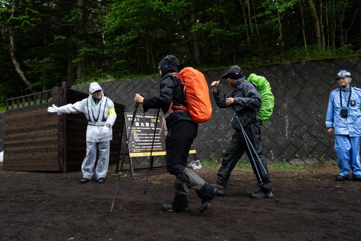登山客は入山料を支払ったことを証明するリストバンドを提示してから入山する/Zhang Xiaoyu/Xinhua/Getty Images