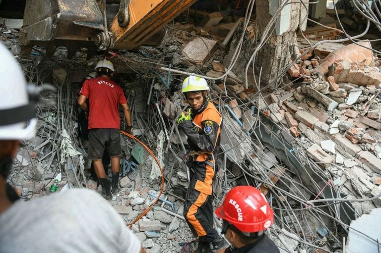 ミャンマー中部マンダレーで、崩壊した建物の瓦礫から生存者の捜索を行う救急要員/SAI AUNG MAIN/AFP via Getty Images