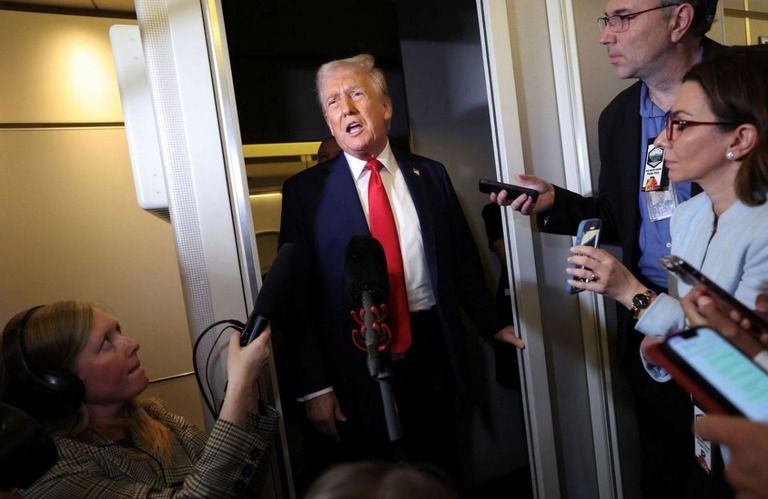 ワシントンへ戻るエアフォースワン（大統領専用機）の機内で記者団に答えるトランプ氏/Kevin Lamarque/Reuters