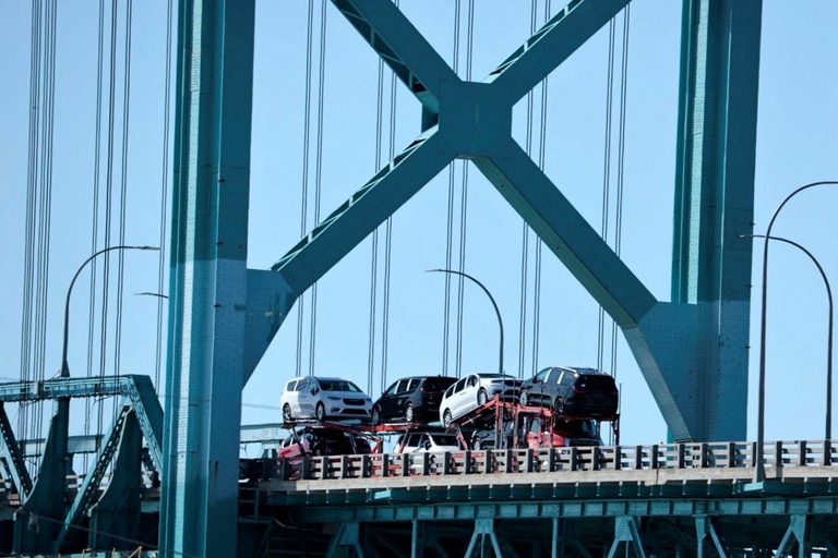 米国とカナダを結ぶ橋を通って輸送される乗用車/Jeff Kowalsky/AFP/Getty Images