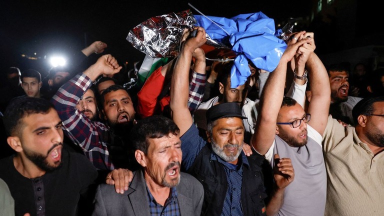 イスラエル兵に撃たれて死亡したパレスチナ系米国人の少年の遺体を運ぶ人々/Mohamad Torokman/Reuters
