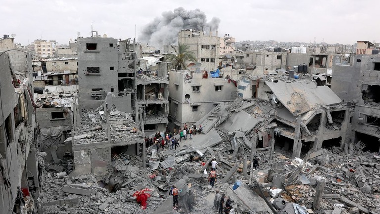イスラエル軍の空爆を受けた建物を調べるパレスチナの人々＝９日、パレスチナ自治区ガザ地区ガザ市/Omar Al-Qattaa/AFP/Getty Images
