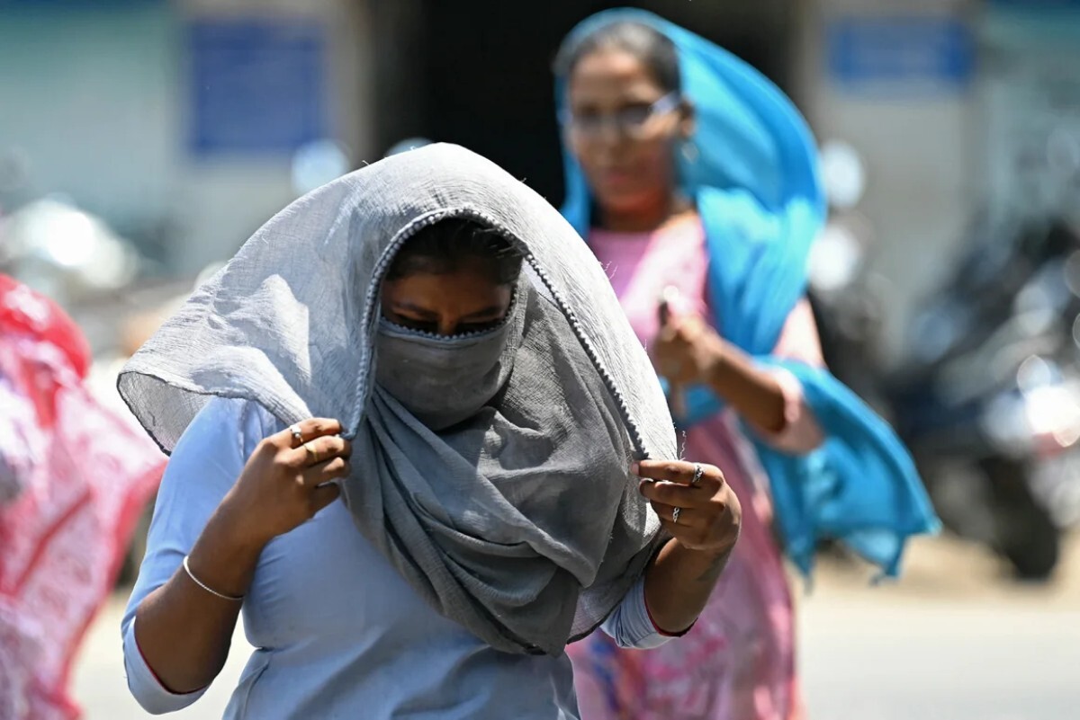 猛暑のなかスカーフで顔を覆う歩行者=8日/R.Satish Babu/AFP/Getty Images