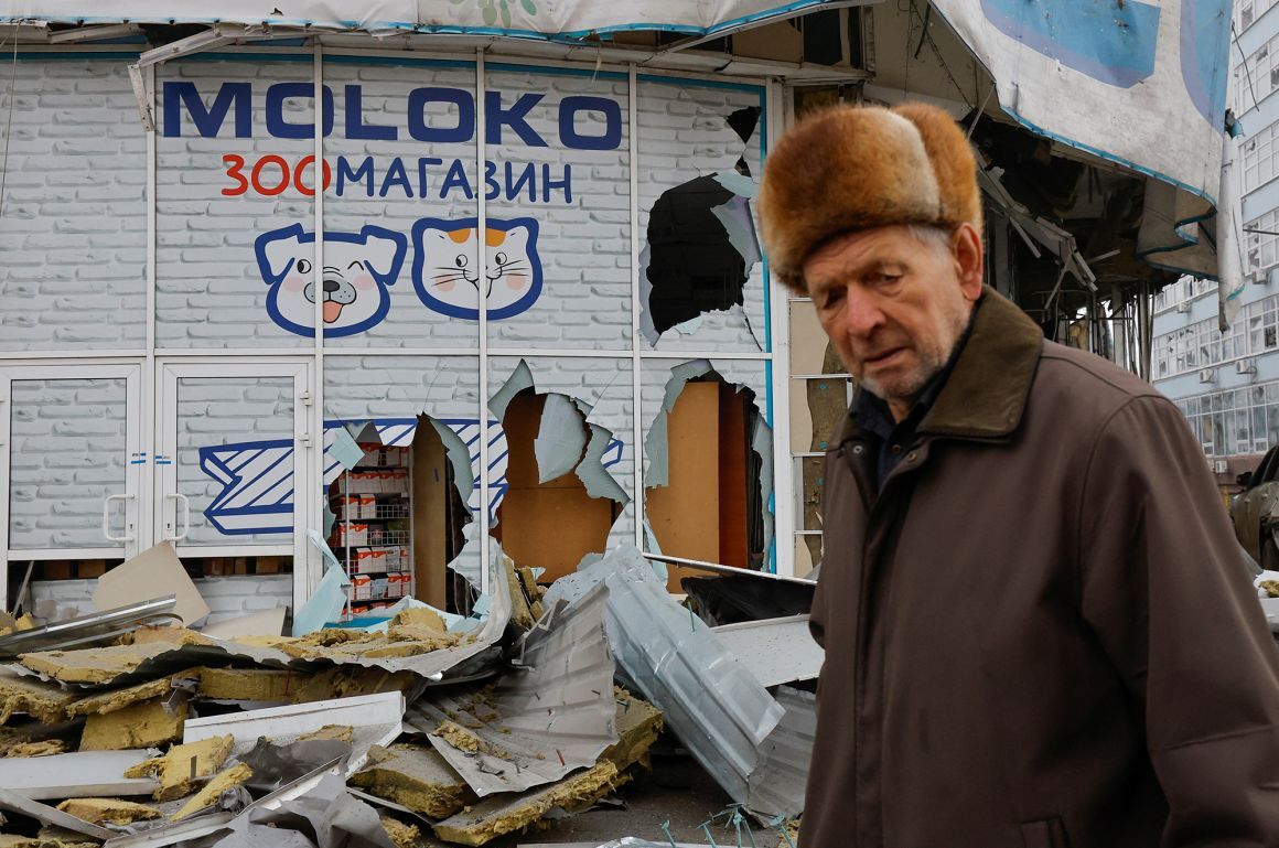 ロシア占領下のドネツクで砲撃によって破損した建物の横を歩く住民=1月/Alexander Ermochenko/Reuters