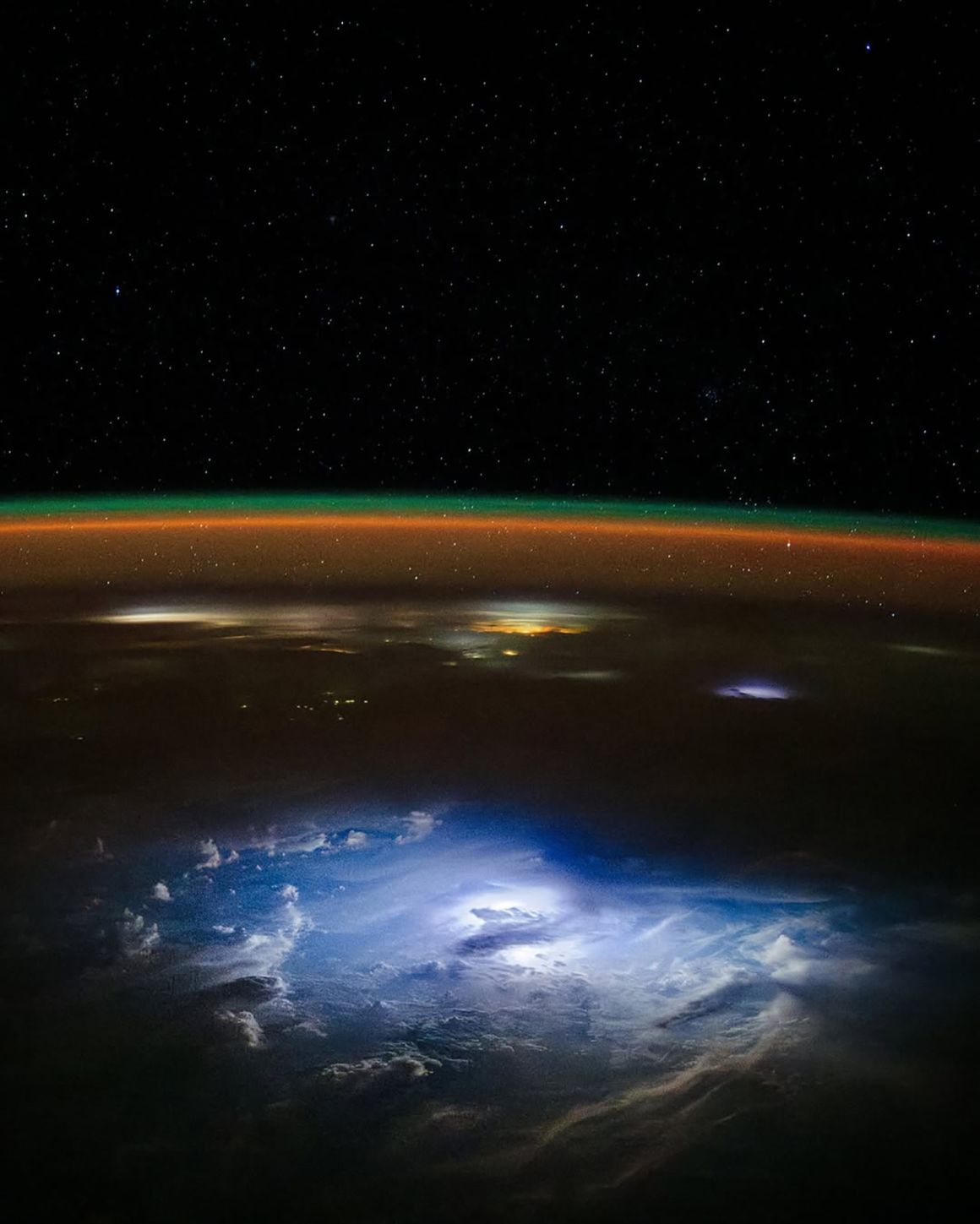 暗い夜に明るい稲妻が太平洋上の雲を照らす様子/Don Pettit/NASA