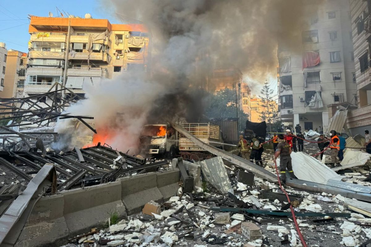 空爆によって発生した火災の消火にあたる消防隊=27日/AFP via Getty Images