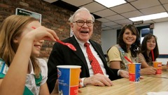 ガールスカウトのメンバーと一緒に座るバフェット氏＝２００８年、オマハ 