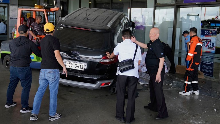 車両の衝突で、救急隊の支援を行う空港の係官＝４日、フィリピン・マニラ/Aaron Favila/AP