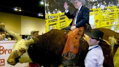 バークシャーの年次会合で模擬の雄牛の上に座るバフェット氏＝２００６年